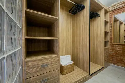 a walk in closet with wooden cabinets and a glass door at Novus Homes Barcelona Plaza España in Barcelona