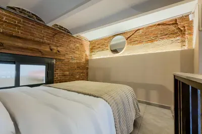 a bedroom with a bed and a brick wall at Novus Homes Barcelona Plaza España in Barcelona