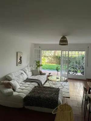 a living room with a white couch and a table at OceanView Shared Apartment in Sant Andreu de Llavaneres