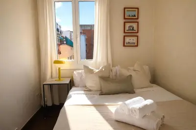 a bedroom with a white bed with towels on it at Boutique Remei in Barcelona