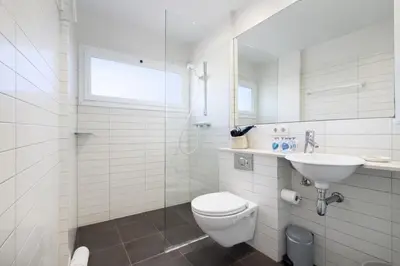 a white bathroom with a toilet and a sink at Boutique Remei in Barcelona