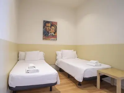 two beds in a room with a picture on the wall at Apartamento en el centro de Barcelona! in Barcelona