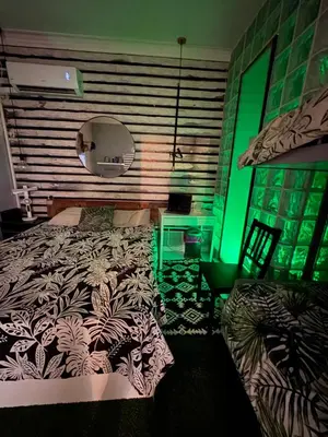 a bedroom with a bed and a green light at stressless house in Barcelona