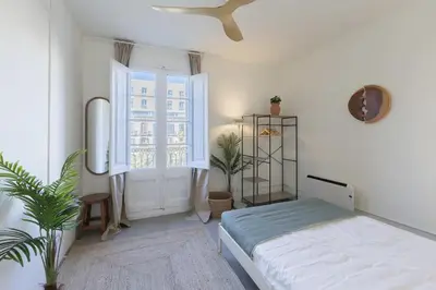 a white bedroom with a bed and a window at ATA Five Rooms Mid term Rental in Barcelona