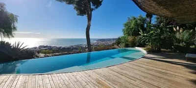 a swimming pool with a view of the ocean at Casa Roca Lujo mediterráneo con piscina infinity in Sitges