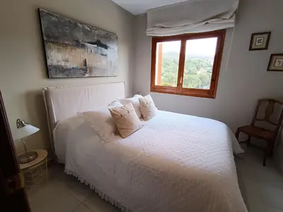 a bedroom with a bed with white sheets and a window at El Mirador de Can Barri BB Vistas Piscina y Desayuno Gourmet in Bigues i Riells