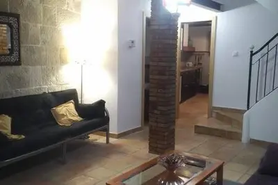 a living room with a black couch and a brick pillar at Casa de pueblo con encanto in Arbós