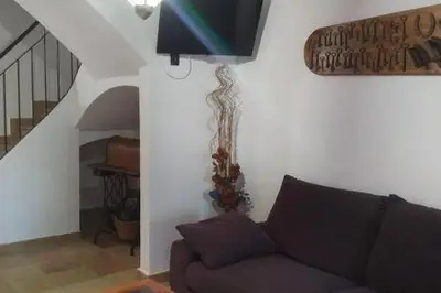 a living room with a couch and a staircase at Casa de pueblo con encanto in Arbós