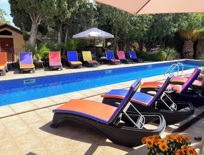 a group of chairs sitting next to a swimming pool at Masia Notari Casabona in Vilanova i la Geltrú