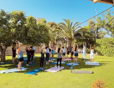 a group of people doing yoga in a park at Masia Notari Casabona in Vilanova i la Geltrú