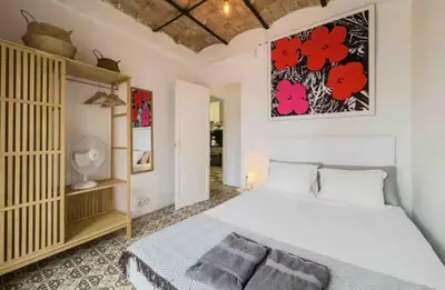 a bedroom with a bed and a painting on the wall at Apartment in BCN 2-1 in Hospitalet de Llobregat