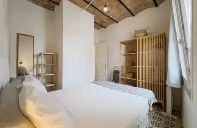 a white bedroom with a bed and a shelf at Apartment in BCN 2-1 in Hospitalet de Llobregat