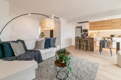 a living room with a white couch and a kitchen at MODERN PENTHOUSE WITH TERRACE ON GRAN VIA DE CARLES III Andorra in Barcelona