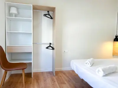 a bedroom with two beds and a refrigerator at Apartment Goya in Vilanova i la Geltrú