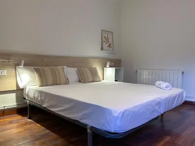a bedroom with a large bed with white sheets at Apt Matisse in Vilanova i la Geltrú