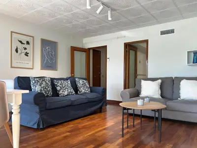 a living room with a blue couch and a table at Apt Matisse in Vilanova i la Geltrú