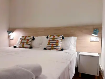 a bedroom with two beds with white sheets and pillows at Apt Matisse in Vilanova i la Geltrú