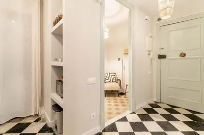a hallway with a white door and a checkered floor at BOLIVIA. NEWLY RENOVATED FULL APARTMENT WITH BRIGHT TERRACE in Barcelona