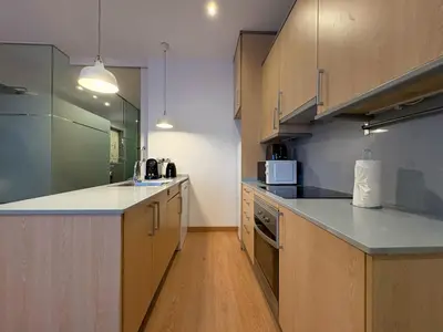 a kitchen with wooden cabinets and a counter top at Stay Unique Sarrià–Sant Gervasi terraza privada in Barcelona
