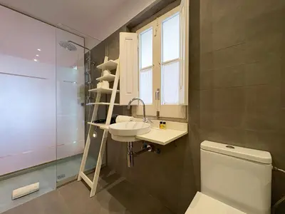 a bathroom with a sink and a toilet and a window at Stay Unique Sarrià–Sant Gervasi terraza privada in Barcelona