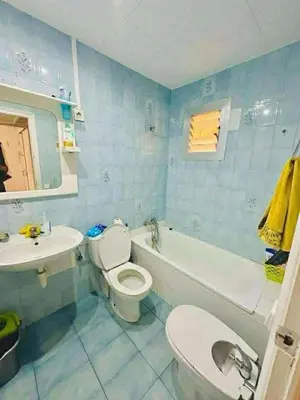 a blue bathroom with a toilet and a sink at Barcelona stay in Hospitalet de Llobregat