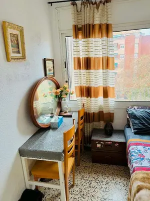 a bedroom with a table and a mirror and a window at Barcelona stay in Hospitalet de Llobregat