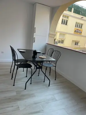 a black table and chairs in a room with a window at Apartamentos Barcelona - Iberia in Barcelona