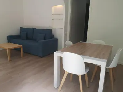 a living room with a table and a blue couch at ApartEasy mid-term ONLY for VACATIONS stays, BORRELL in Barcelona