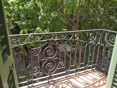 a wrought iron railing on a balcony with trees at ApartEasy mid-term ONLY for VACATIONS stays, BORRELL in Barcelona
