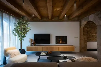 a living room with a couch and a tv at Villa Mas Summit in Collsuspina