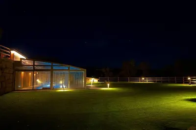 a building with lights in a field at night at Villa Mas Summit in Collsuspina