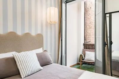a bedroom with a bed and a balcony with a chair at Luminoso apartamento con balcon en Sagrada Familia in Barcelona