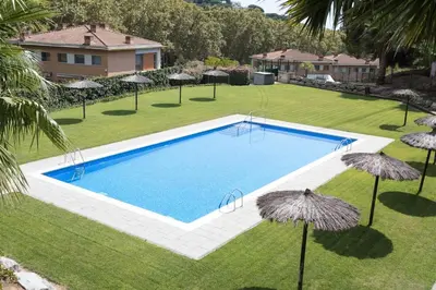 a swimming pool in a yard with umbrellas at TARRACO - Private Pool Villa in Arenys de Munt in Arenys de Munt