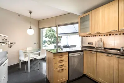 a kitchen with wooden cabinets and a table and a dining room at TARRACO - Private Pool Villa in Arenys de Munt in Arenys de Munt
