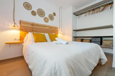 a bedroom with a large white bed with yellow pillows at Hauzify I Casa Olivella A in Olivella
