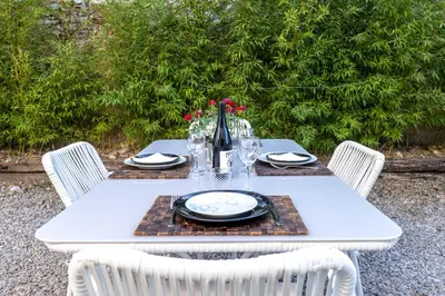 a table with plates and glasses and a vase on it at Hauzify I Casa Olivella A in Olivella