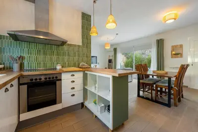 a kitchen with a table and a stove top oven at Hauzify I Casa Olivella A in Olivella