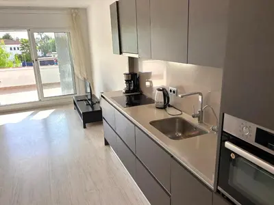 a kitchen with a sink and a microwave at Apartamento Mallorca, muy cerca de la playa in Sitges