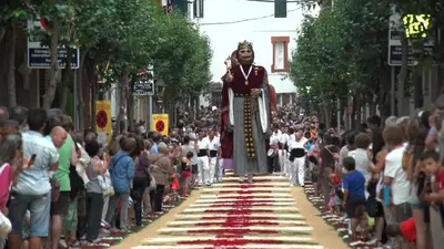 a man walking down a street with a crowd of people at Santa Barbara, in downtown Sitges in Sitges