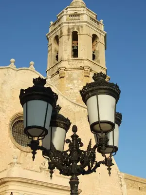a street light in front of a building with a clock tower at Apartamentos Montserrat in Sitges
