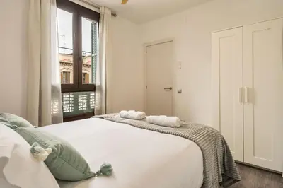 a bedroom with two beds and a window at Eixample Pedestrian Gem Balcony Bathtub AC in Barcelona