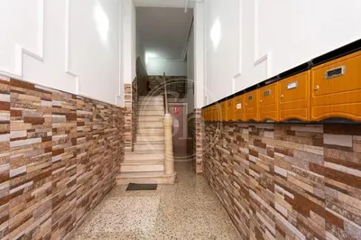a bedroom with a bed with white sheets and a dresser at Apartamento céntrico en Poble Sec in Barcelona