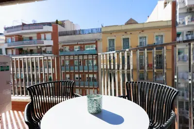 a white table and chairs on a balcony with a building at ApartEasy mid-term ONLY for VACATIONS stays, EIXAMPLE CENTER in Barcelona