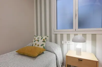a bedroom with a bed with a lamp and a pillow at ApartEasy mid-term ONLY for VACATIONS stays, EIXAMPLE CENTER in Barcelona