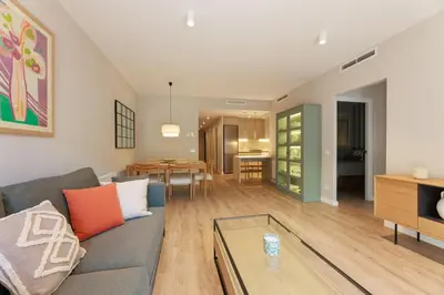 a living room with a couch and a table at ApartEasy mid-term ONLY for VACATIONS stays, EIXAMPLE CENTER in Barcelona