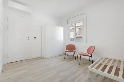 a white room with two chairs and a table at Apartahotel Sant Marti Suites in San Martín Sarroca