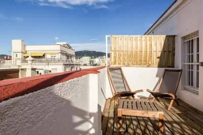 two chairs sitting on the balcony of a building at ApartEasy mid-term ONLY for VACATIONS stays, ATIC GRACIA in Barcelona