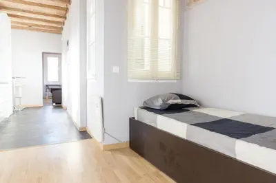 a bedroom with a bed in a white room at ApartEasy mid-term ONLY for VACATIONS stays, ATIC GRACIA in Barcelona