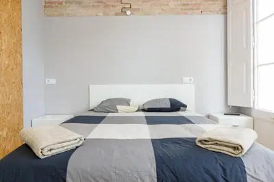 a bedroom with a large bed with two pillows at ApartEasy mid-term ONLY for VACATIONS stays, ATIC GRACIA in Barcelona