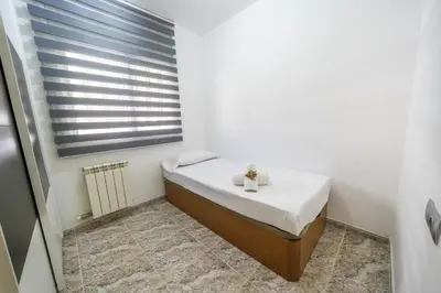 a small bedroom with a bed and a window at HomeHolidaysRentals Coquette - Costa Barcelona in Pineda de Mar